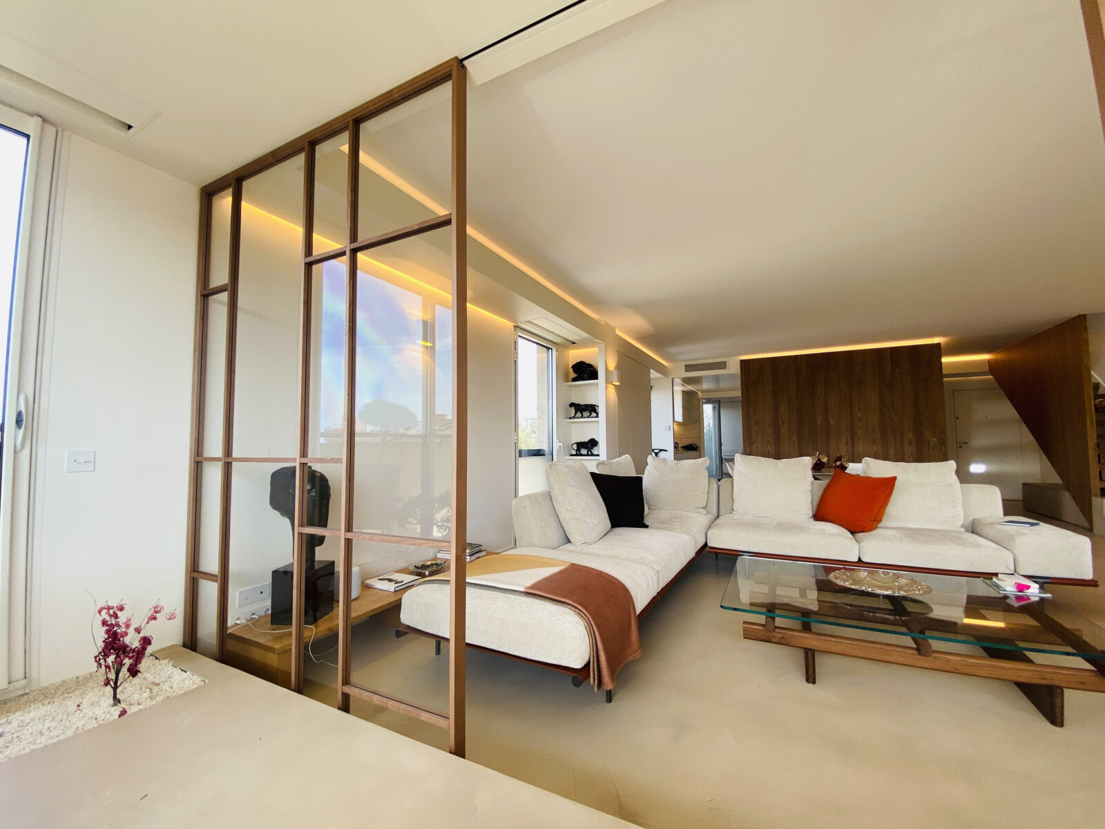 Panneaux coulissants vitrés ouvrant sur le salon, canapés blancs et table basse en verre, duplex loft Aix-en-Provence