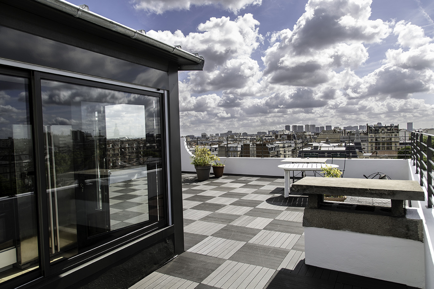 Terrasse en toiture, sol en damier et vue sur les toits de Paris