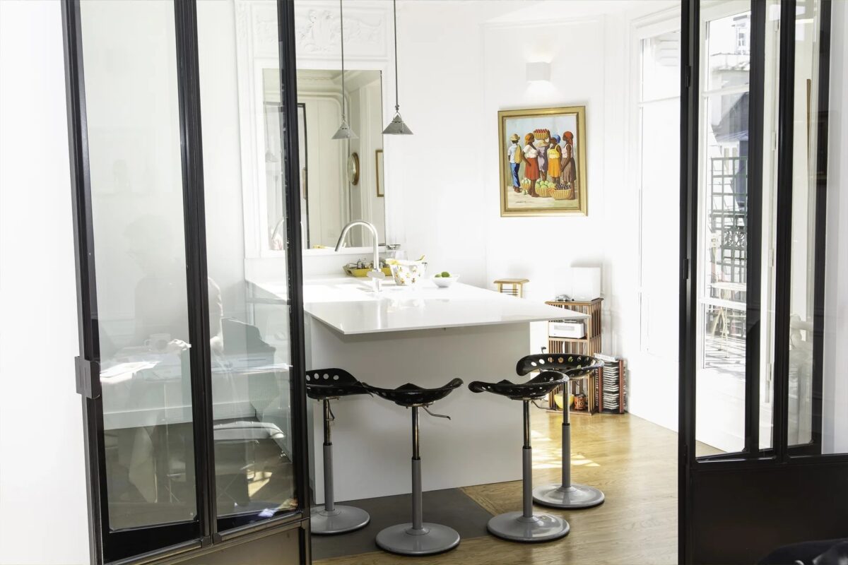 Cuisine à îlot blanc sous verrière d'atelier